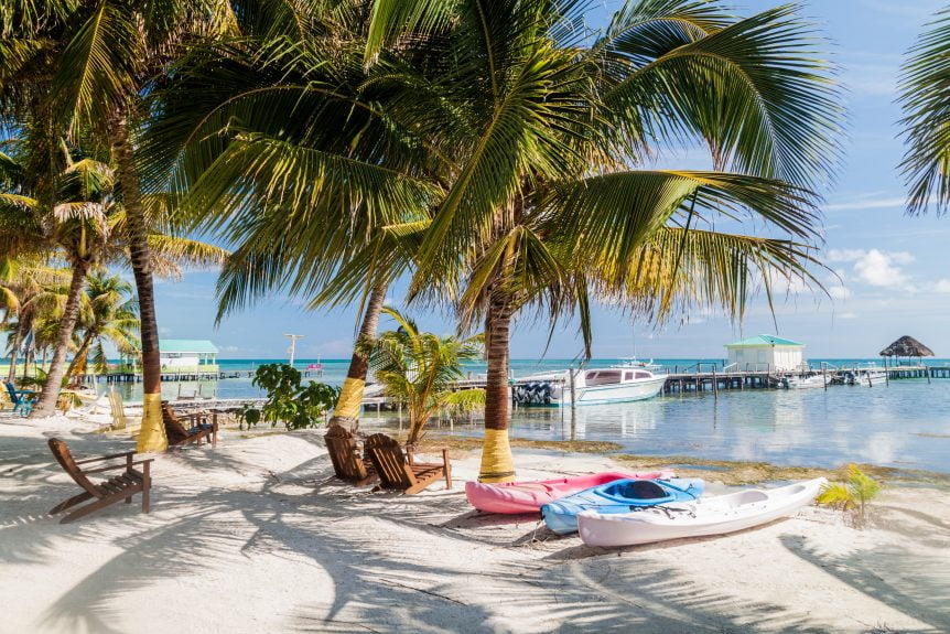 beach in Belize with kayaks and chairs on beach